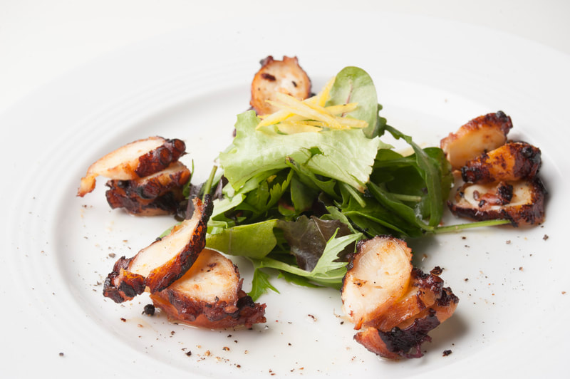 Plated grilled Octopus and salad at Open Garden Restaurant in Naoussa Paros Greece
